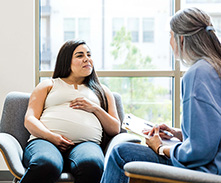 pregnant woman speaking to social worker